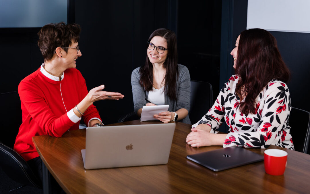 Drei Frauen in einem Besprechungsraum.